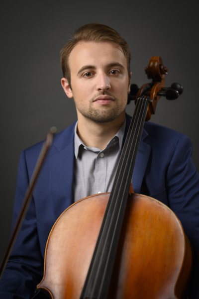 A man poses with a cello.